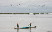 Young boys row along a flooded tract of their ranch by the Amazon River.