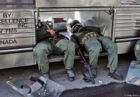 Exhausted policeman rest during riots at the Summit of the Americas.